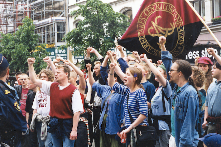 Björn Söderberg, står längst fram i en människoskara där alla håller upp en knuten näve. Bilden syns i samband med information om civilkuragepriset, som delas ut till minne av Björn Södernerg, som 1999 blev mördad av nazister för sitt fackliga engagemang